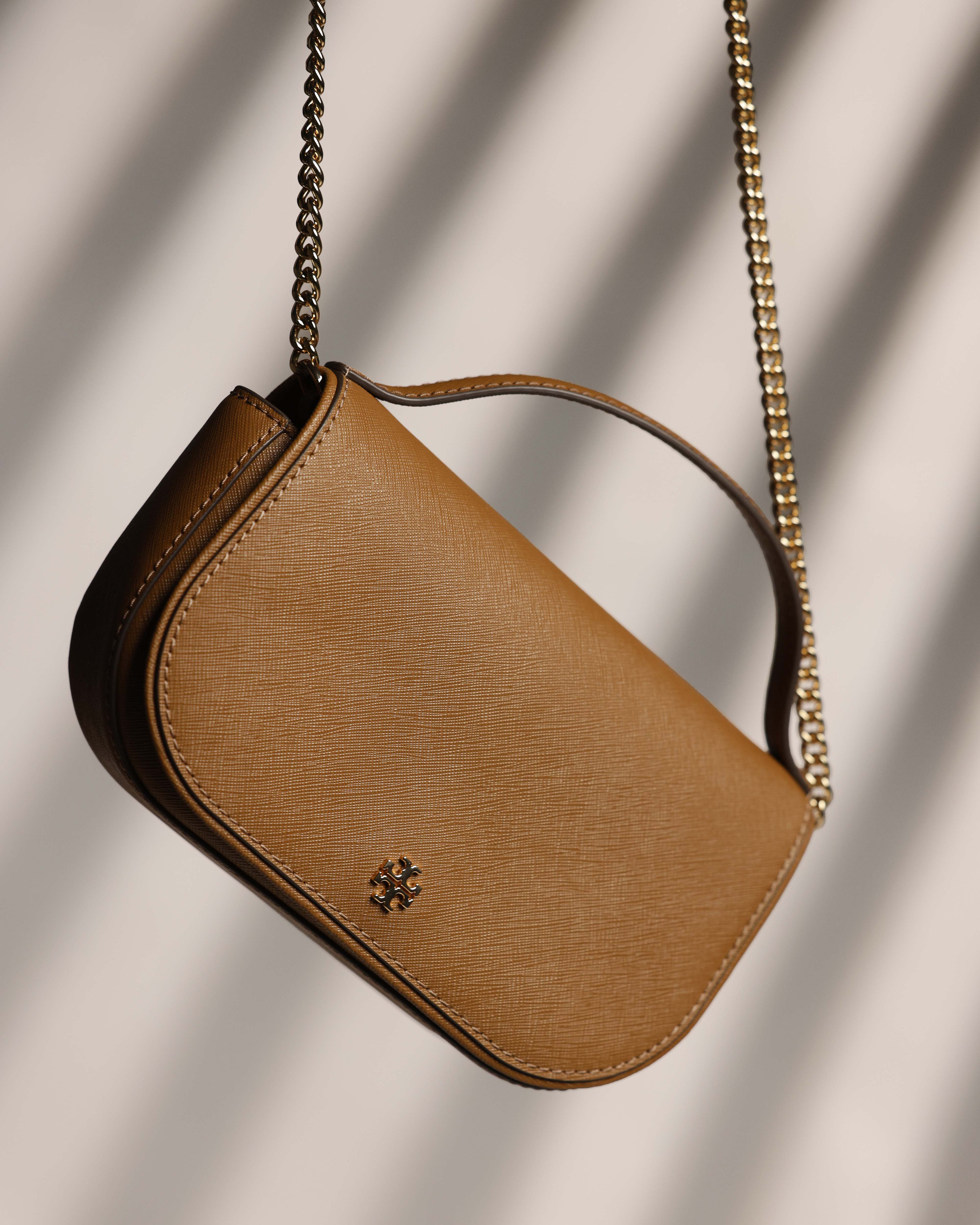 Small brown leather purse on beige background