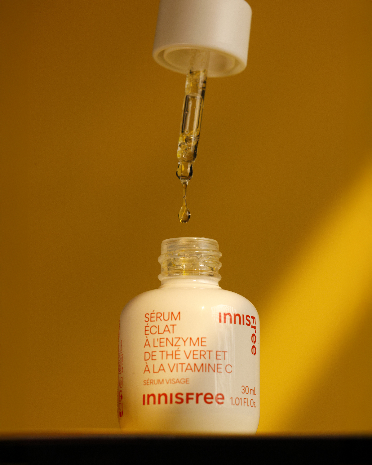 Skincare dropper bottle on orange background